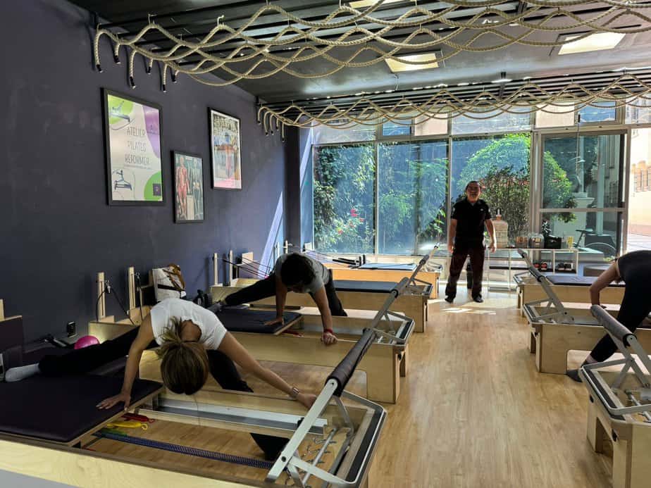 Inicio 4 people in a room with a couple of people doing pilates